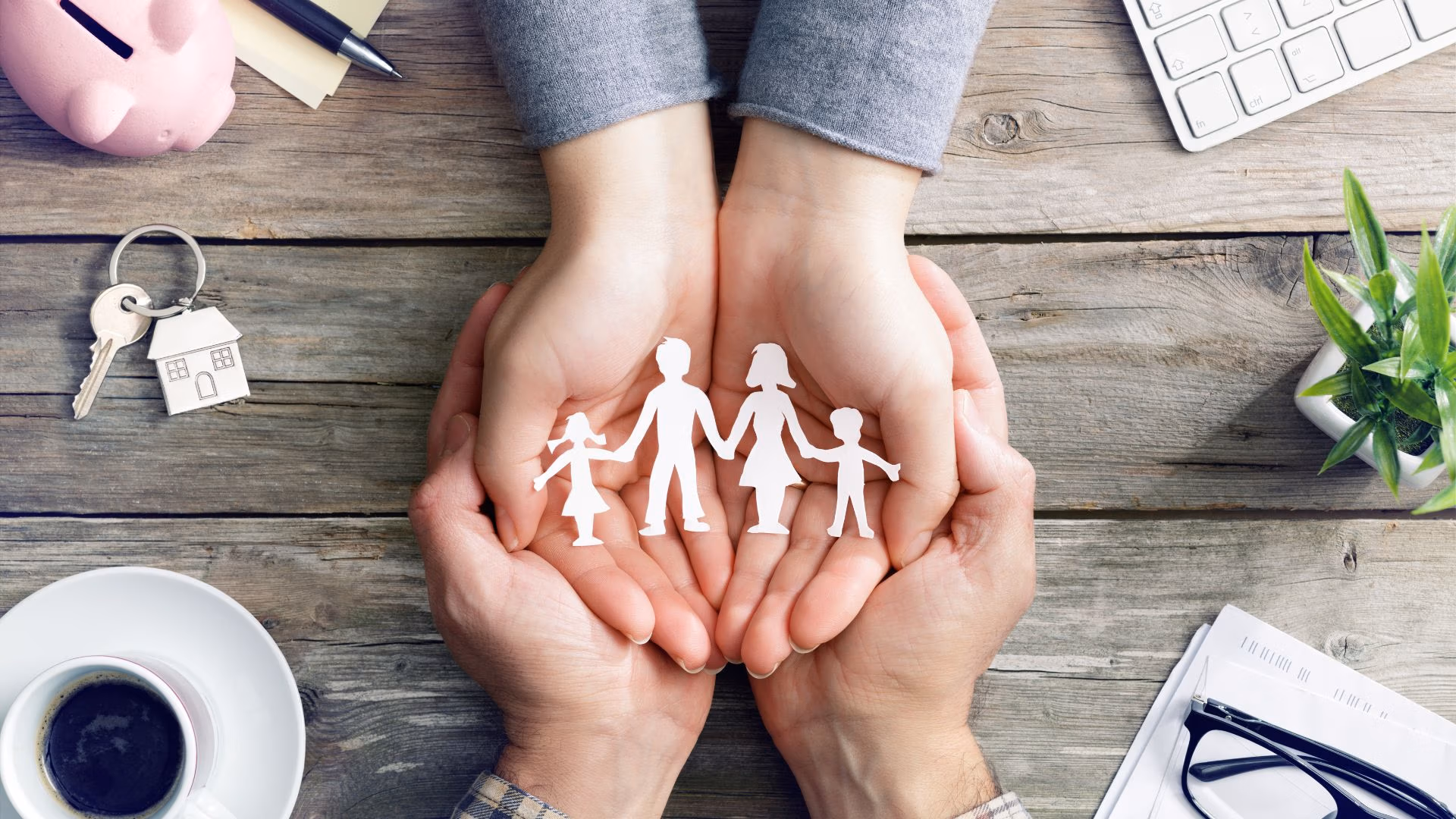 Hands cradling paper cutout of a blended family, symbolizing Virginia estate planning to protect spouse, kids, and home