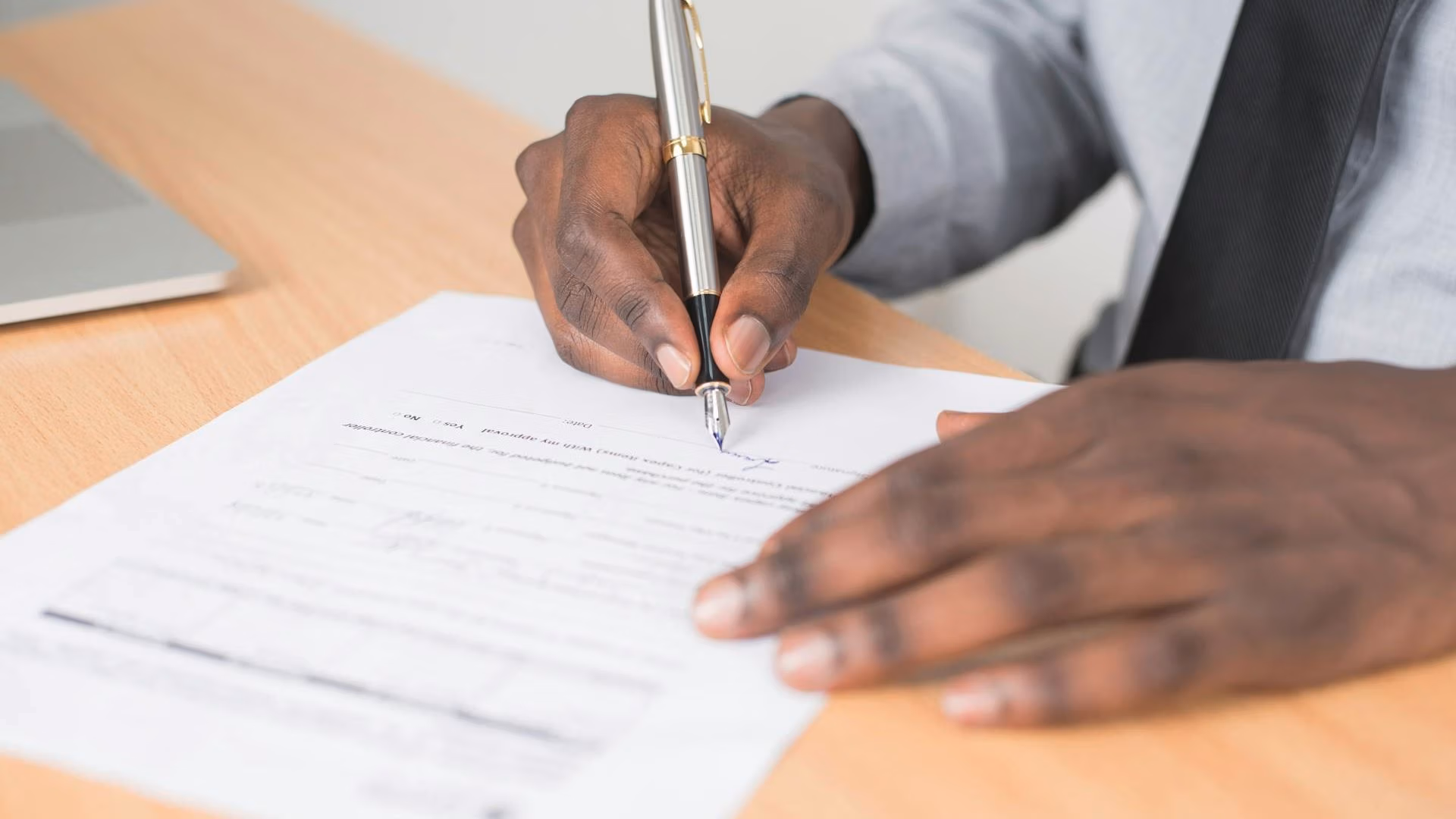 Close-up of a man signing legal documents, representing guardianship, conservatorship, and fiduciary responsibilities.