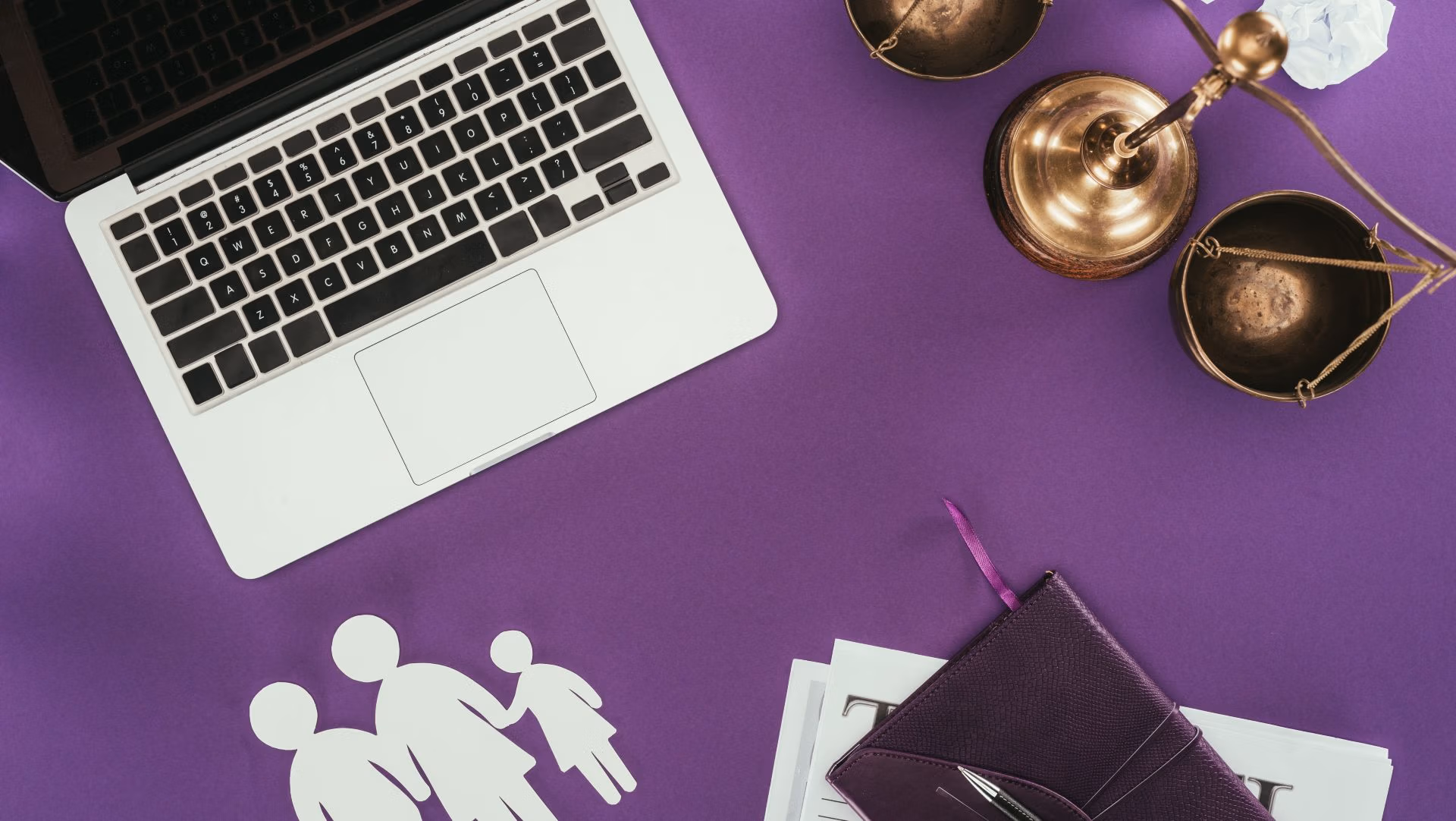 Laptop, justice scales, and family cutout on a purple desk, symbolizing guardianship and conservatorship planning in Virginia.