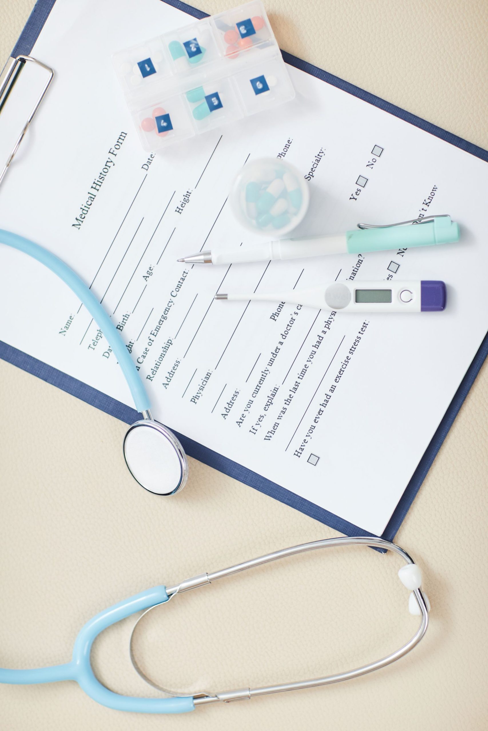 Top view background of medical form on clipboard with stethoscope over it