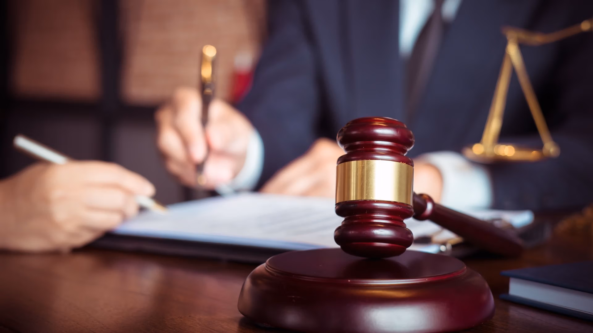 Judge gavel with lawyer and client signing legal documents
