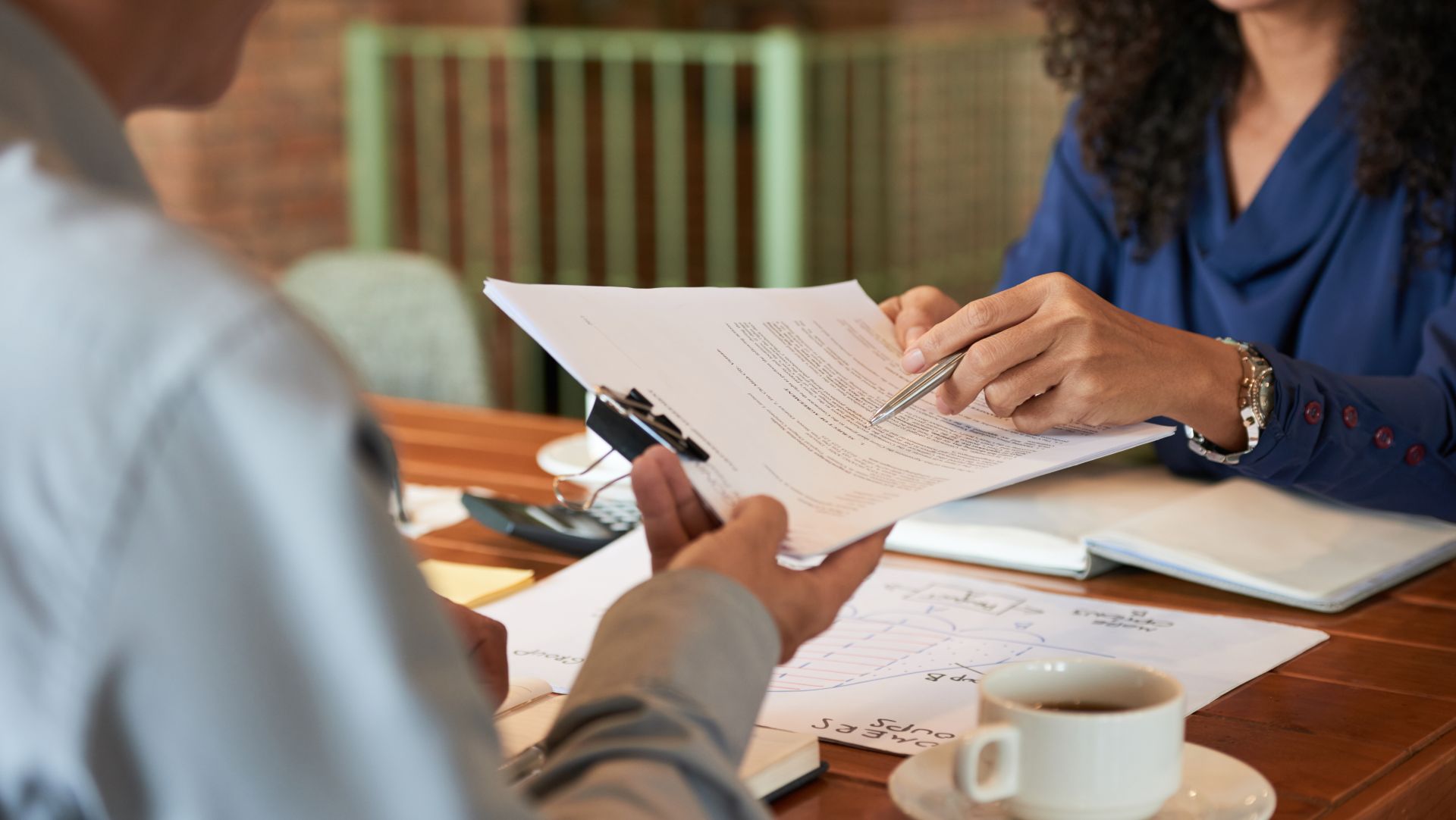 People reviewing and discussing legal documents with notes and charts on a desk.