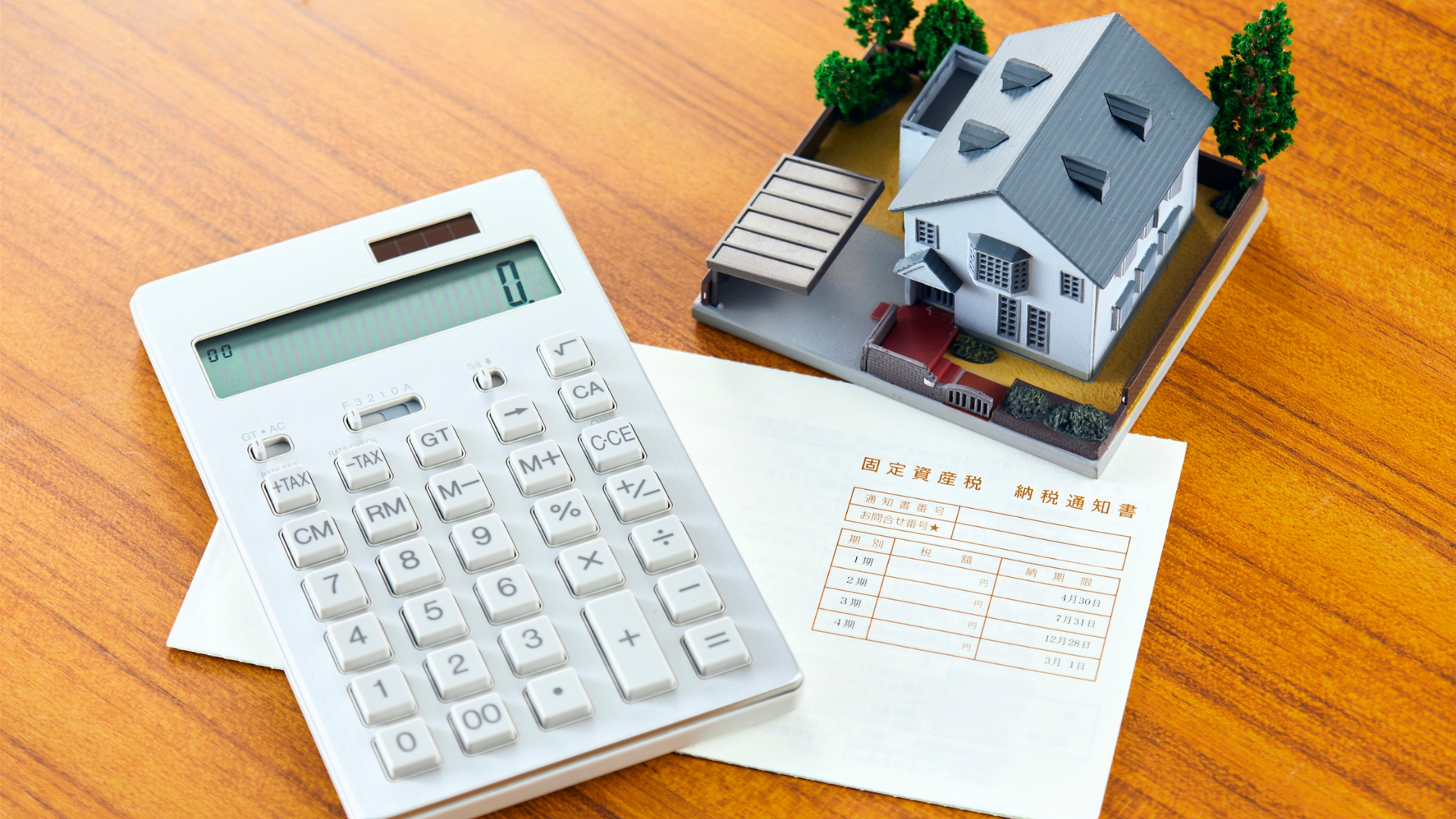 Calculator, tax document, and miniature house model representing local probate taxes in Virginia.