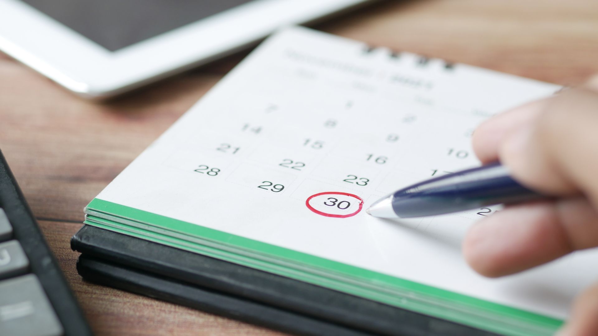 Hand marking calendar date 30 with a pen, symbolizing the 30-day probate deadline for executors in Virginia.