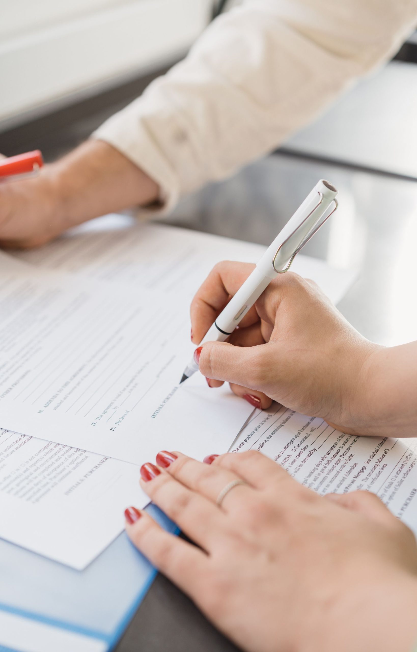 Person signing legal probate documents with pen on desk.