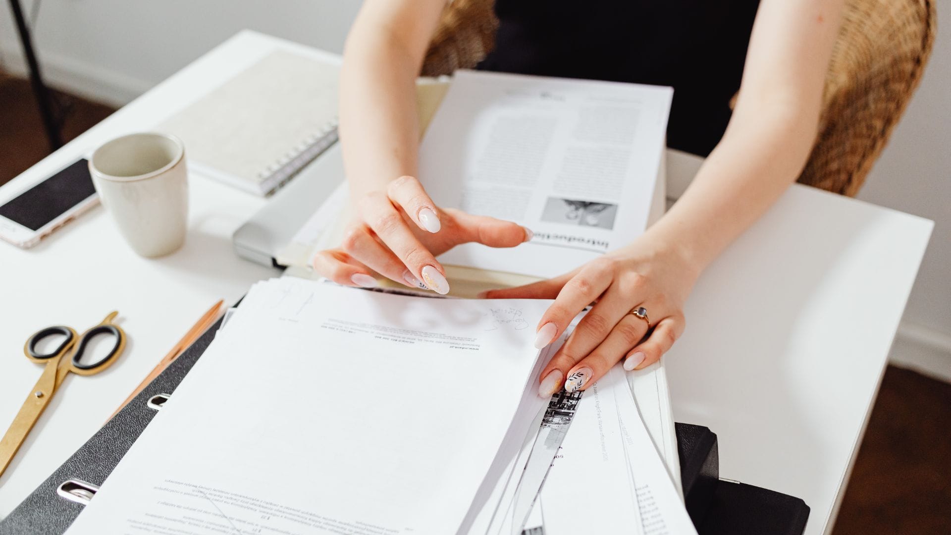 Executor sorting probate paperwork and estate documents at kitchen table