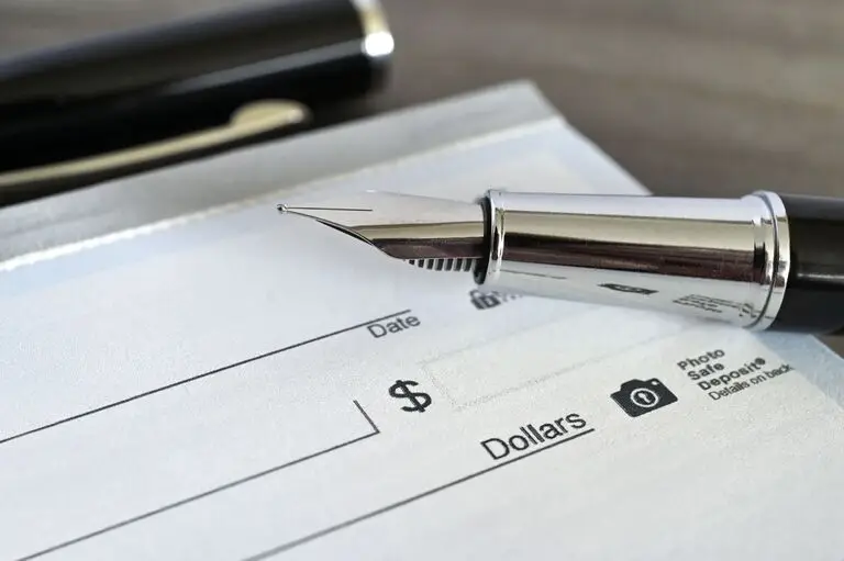 Fountain pen on a blank check for paying nursing home costs in Virginia