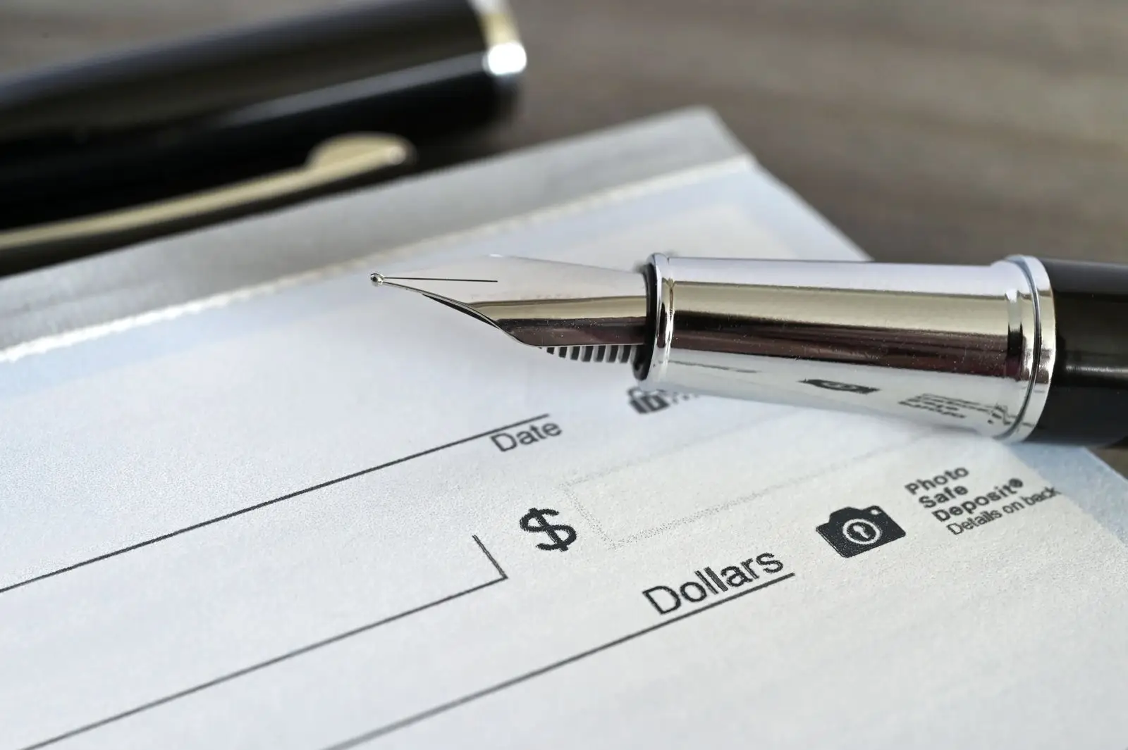 Fountain pen on a blank check for paying nursing home costs in Virginia